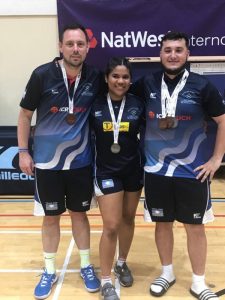 Three table tennis team players with medals around their necks